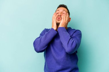 Genç İspanyol adam mavi arka planda yalnızdı sızlanıyor ve ağlıyordu..