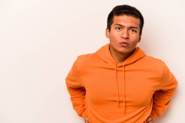 Beyaz arka planda izole edilmiş genç İspanyol adam gördüğü bir şey yüzünden şoka uğruyor..