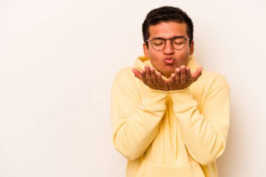 Beyaz arka planda izole edilmiş, dudakları kıvrılmış ve hava öpücüğü yollamak için avuç içi tutan İspanyol bir adam..