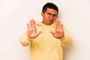 Beyaz arka planda izole edilmiş genç İspanyol adam elini uzatmış, dur işareti göstererek seni engelliyor..