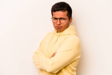 Beyaz arka planda izole edilmiş, hoşnutsuzca kaşlarını çatmış, kollarını kavuşturmuş genç bir İspanyol..