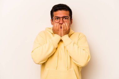 Beyaz arka planda izole edilmiş, tırnak yiyen, gergin ve endişeli genç bir adam..