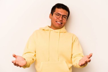 Beyaz arka planda izole edilmiş genç bir İspanyol hoş geldin ifadesi sergiliyor..