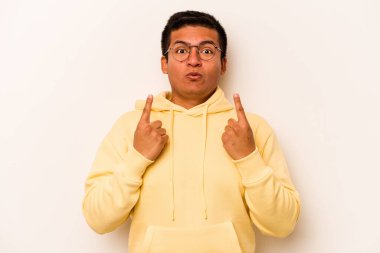 Beyaz arka planda izole edilmiş genç bir İspanyol ağzı açık bir şekilde yukarı işaret ediyor..