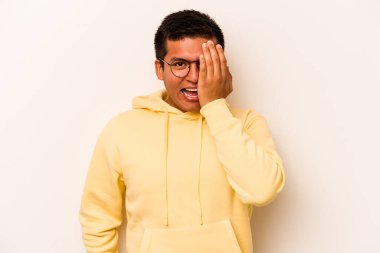 Beyaz arka planda izole edilmiş, yüzünün yarısını palmiye ile örterek eğlenen genç bir İspanyol..