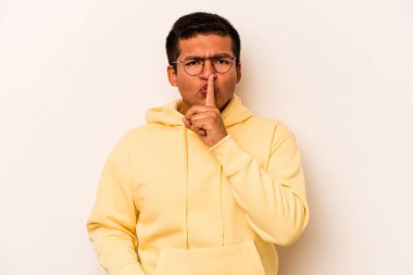 Beyaz arka planda izole edilmiş genç İspanyol bir adam ya sır saklıyor ya da sessizlik istiyor..