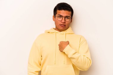 Beyaz arka planda izole edilmiş genç İspanyol adam parmağını göstererek şaşırdı, geniş bir gülümsemeyle..