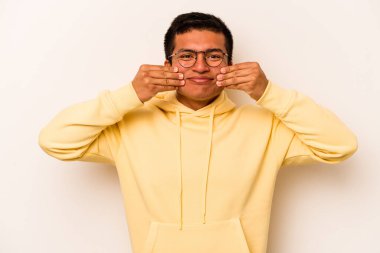 Latin kökenli genç bir adam beyaz arka planda iki seçenek arasında kuşkulanıyor..