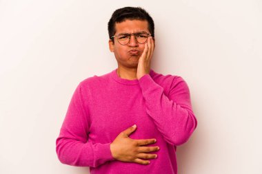 Beyaz arka planda izole edilmiş genç İspanyol adam yanakları patlatıyor, yorgun bir ifadesi var. Yüz ifadesi kavramı.