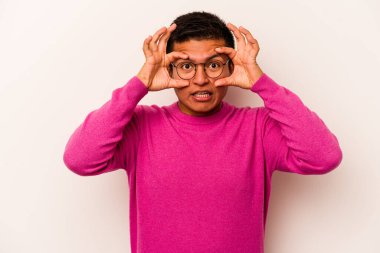 Beyaz arka planda izole edilmiş genç bir İspanyol başarılı bir fırsat yakalamak için gözlerini açık tutuyor..