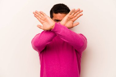 Beyaz arka planda izole edilmiş genç İspanyol adam iki kolu çapraz tutuyor, inkar kavramı.