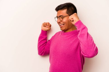 Beyaz arka planda izole edilmiş genç bir İspanyol özel bir günü kutluyor, atlıyor ve enerjiyle kollarını kaldırıyor..