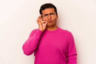 Beyaz arka planda izole edilmiş genç İspanyol adam parmakları dudaklarında bir sır saklıyor..