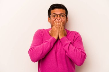 Beyaz arka planda izole edilmiş genç İspanyol adam elleri endişeli bir şekilde ağzı örtüyor..
