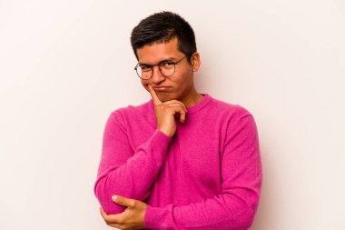 Latin kökenli genç bir adam beyaz arka planda izole edilmiş. Bir strateji planlıyor, bir iş yolu düşünüyor..