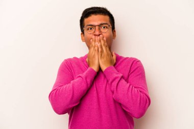 Beyaz arka planda izole edilmiş genç İspanyol adam şok olmuş, ağzı ellerle kaplanmış, yeni bir şey keşfetmeye hevesli..