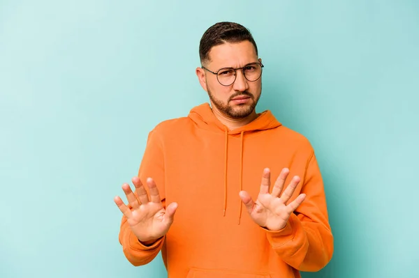 Young Hispanic Man Isolated Blue Background Rejecting Someone Showing Gesture — стоковое фото