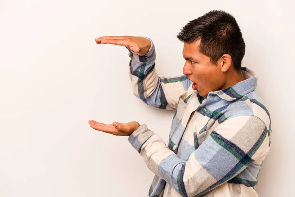 Joven Hombre Hispano Aislado Sobre Fondo Blanco Sorprendido Sorprendido Sosteniendo — Foto de Stock