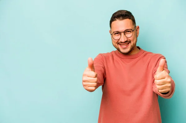 Jonge Latino Man Geïsoleerd Blauwe Achtergrond Glimlachen Heffen Duim Omhoog — Stockfoto