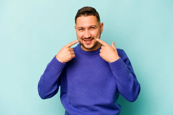 Young Hispanic Man Isolated Blue Background Smiles Pointing Fingers Mouth — стоковое фото