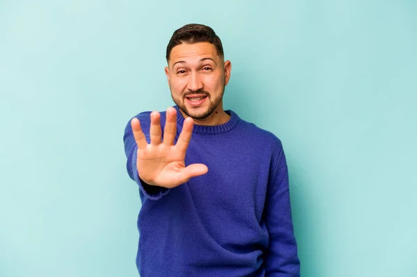 Jonge Spaanse Man Geïsoleerd Blauwe Achtergrond Glimlachend Vrolijk Tonen Nummer — Stockfoto