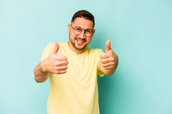 Jonge Spaanse Man Geïsoleerd Blauwe Achtergrond Hijsen Beide Duimen Omhoog — Stockfoto