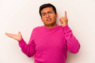 Latin kökenli genç bir adam beyaz arka planda izole edilmiş ve elinde bir ürün tutuyor..