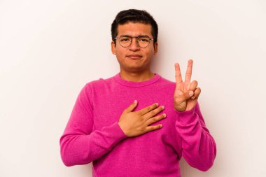 Genç İspanyol bir adam beyaz arka planda izole edilmiş yemin ediyor, elini göğsüne koyuyor..