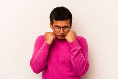 Latin kökenli genç bir adam beyaz arka planda izole edilmiş. Yumruk atıyor, sinirleniyor, kavga ediyor..