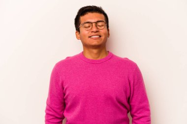 Beyaz arka planda izole edilmiş genç İspanyol adam gülüyor ve gözlerini kapıyor, rahatlamış ve mutlu hissediyor..