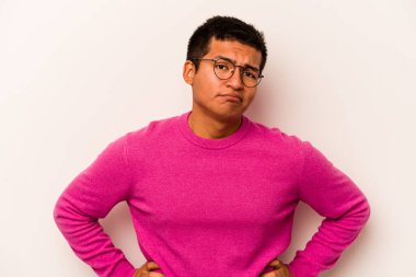 Genç İspanyol adam beyaz arka planda izole edilmiş üzgün, ciddi yüzlü, mutsuz ve hoşnutsuz..