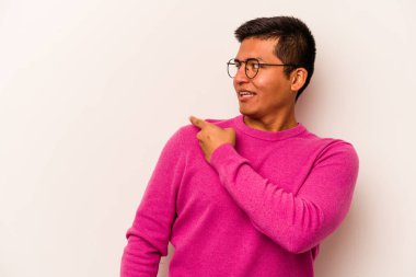 Beyaz arka planda soyutlanmış genç İspanyol adam gülümseyen, neşeli ve keyifli bir kenara bakıyor..