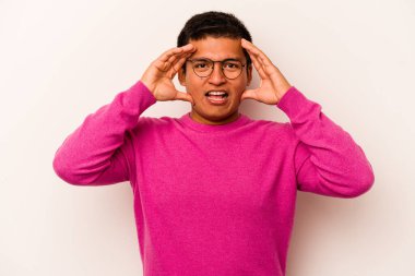 Latin kökenli genç bir adam beyaz arka planda izole edilmiş. Hoş bir sürprizle karşılaşıyor, heyecanlı ve el kaldırıyor..