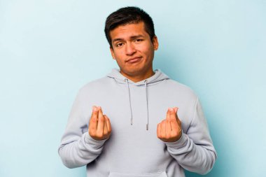 Genç İspanyol adam mavi arka planda izole edilmiş, parasız olduğunu gösteriyor..