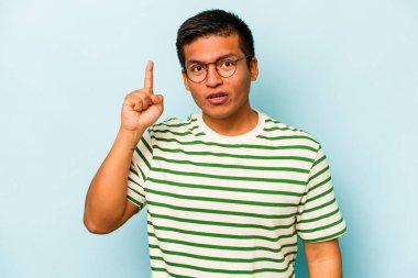 Genç İspanyol bir adam mavi arka planda izole bir fikir, ilham konsepti var.