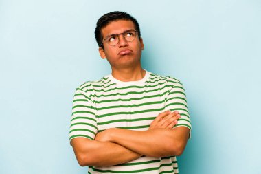 Genç İspanyol adam mavi arka planda izole edilmiş. Tekrarlanan bir görevden yorulmuş..