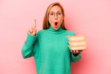 Beyaz tenli genç bir kadın pembe arka planda saklanmış vaziyette harika bir fikri var, yaratıcılık kavramı..