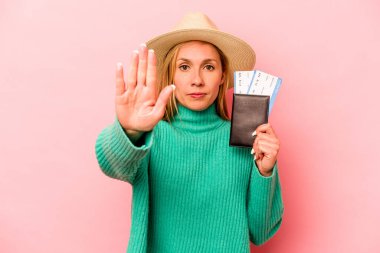 Pembe arka planda izole edilmiş pasaport taşıyan beyaz bir kadın elini uzatmış, dur işaretini göstererek seni engelliyor..