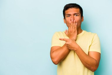 Mavi arka planda izole edilmiş genç bir İspanyol yan tarafı gösteriyor.