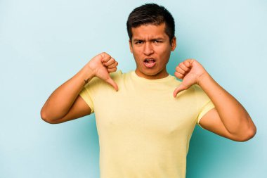 Mavi arka planda izole edilmiş genç bir İspanyol gururlu ve kendinden emin hissediyor, örnek olarak..