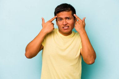 Mavi arka planda izole edilmiş genç İspanyol adam işaret parmağıyla bir hayal kırıklığı gösteriyor..