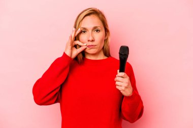 Pembe arka planda izole edilmiş, dudakları dudaklarında bir sır saklayan beyaz bir kadın..