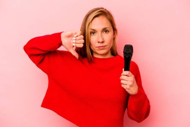 Pembe arka planda izole edilmiş genç beyaz kadın hoş olmayan bir jest sergiliyor. Anlaşmazlık konsepti.
