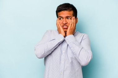 Genç İspanyol adam mavi arka planda izole edilmiş korkmuş ve korkmuş..