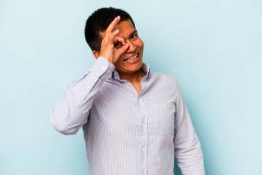 Latin kökenli genç adam mavi arka planda izole edilmiş. Heyecanlı..