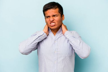 Genç İspanyol bir adam mavi arka planda izole edilmiş, sabit yaşam tarzından dolayı boyun ağrısı çekiyor..