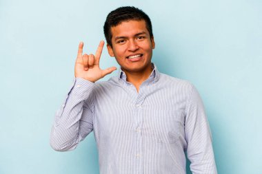 Genç İspanyol asıllı bir adam mavi arka planda izole edilmiş boynuzları bir devrim konsepti olarak gösteriyor..