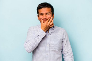 Latin kökenli genç bir adam mavi arka planda iki seçenek arasında kuşkulanıyor..