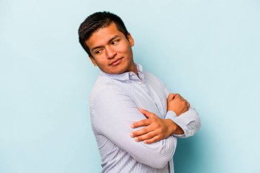 Genç İspanyol adam mavi arka planda izole edilmiş gülüyor ve eğleniyor..