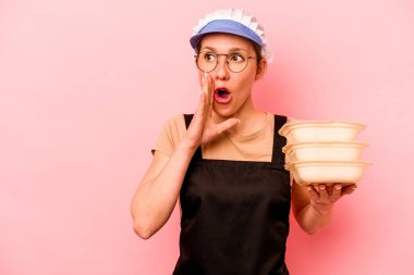 Pembe arka planda izole edilmiş genç aşçı kadın gizli bir sıcak fren haberinin olduğunu ve kenara baktığını söylüyor.